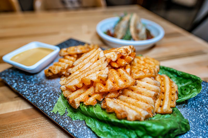 Loaded Waffle Fries with toppings and dipping sauce